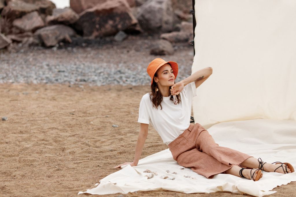 A woman in a bucket hat on a beach